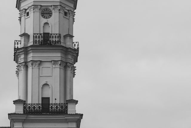 This black and white photograph features a historic clock tower against a cloudy sky. Use this for travel blogs, architectural studies, or historical presentations.