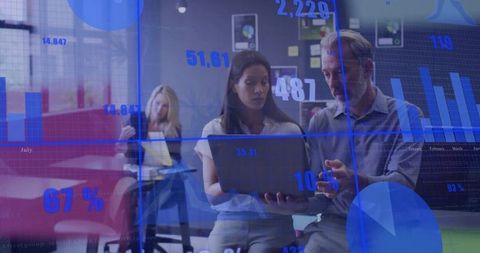 Business team analyzing digital data dashboard on laptop with blue charts overlay