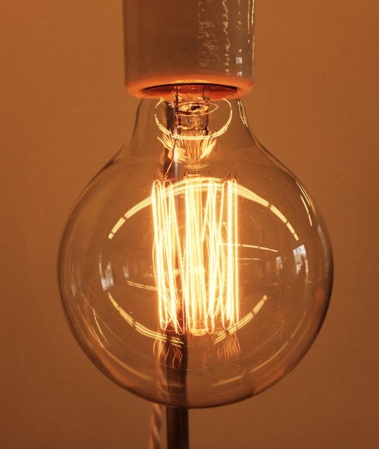 Glowing Vintage Edison Light Bulb Against Warm Orange Background - Download Free Stock Photos Pikwizard.com