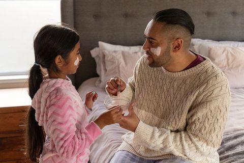 Father and daughter applying skincare in pajamas morning bonding and cozy self-care