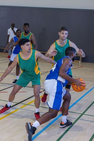 Adult Basketball Players Competing in Indoor Game