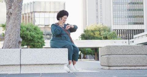 Confident Woman Multitasking with Smartphone and Smartwatch Outdoors