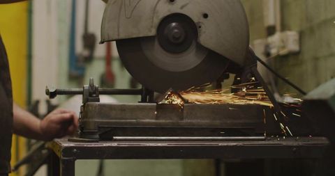 Cutting Steel Using Bench-Mounted Abrasive Chop Saw Creating Bright Sparks in Workshop