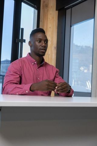 African Man Gesturing at Conference Table in Modern Office