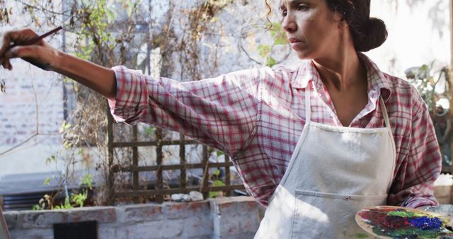 Focused Female Artist Painting Outdoors in Sunny Garden - Download Free Stock Images Pikwizard.com