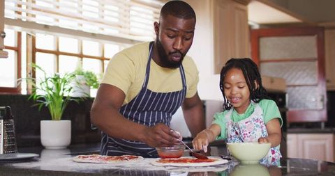 Father and Daughter Sharing Quality Time Preparing Homemade Pizzas