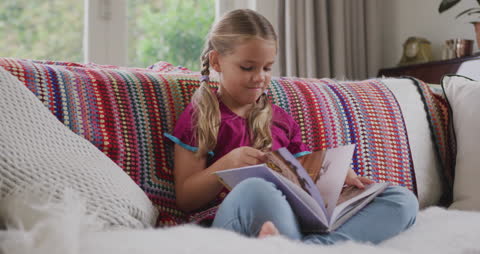 Young Girl Enjoying Storybook on Colorful Couch