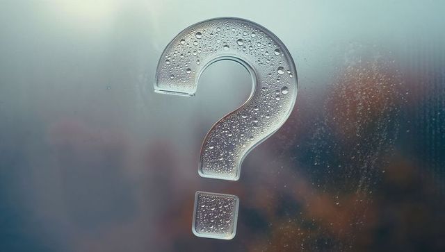Transparent question mark on wet glass with condensation droplets