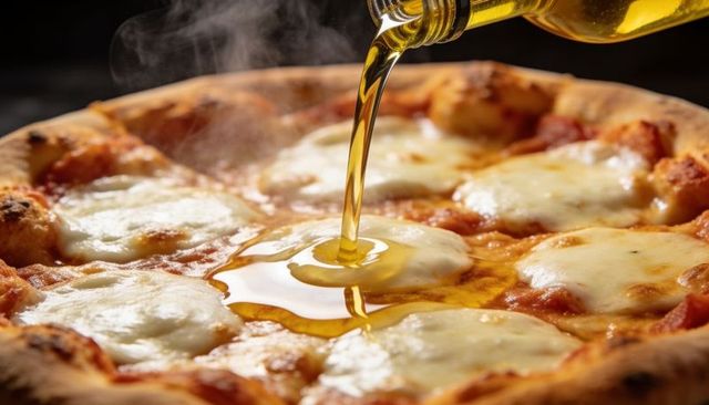 Pouring olive oil over hot margherita pizza with melting mozzarella and crispy crust