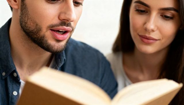 Young couple reading paperback together man reading aloud while partner listens cozy moment