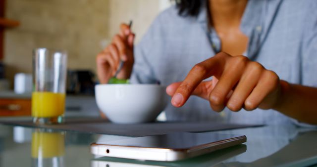 Person Having Breakfast While Using Smartphone at Kitchen Table - Download Free Stock Images Pikwizard.com