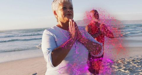 Senior Woman Meditating on Beach Surrounded by Vibrant Energy
