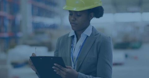 Industrial supervisor managing inventory with clipboard in warehouse