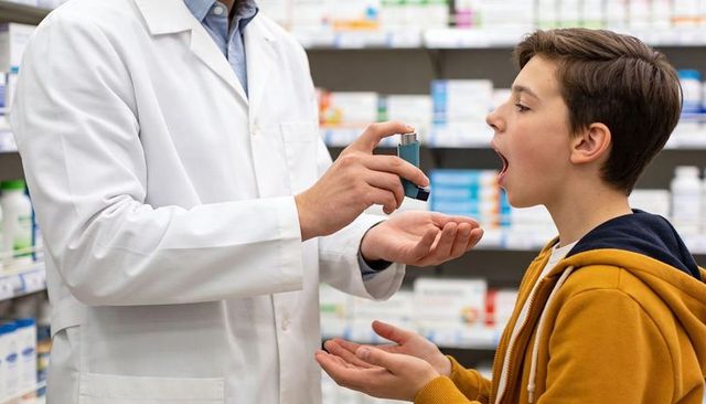 Pharmacist demonstrating inhaler technique to teenage patient at retail pharmacy counter