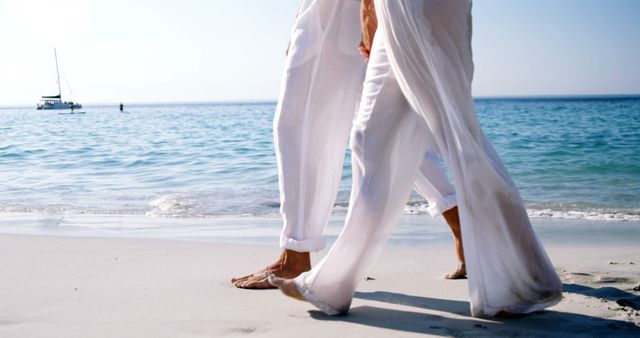 Couple Walking on Sandy Beach in White Pants on Sunny Day - Download Free Stock Images Pikwizard.com