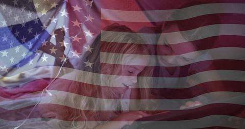 Sisters Relaxing with Tablet Under Patriotic Setting with Flag Overlay