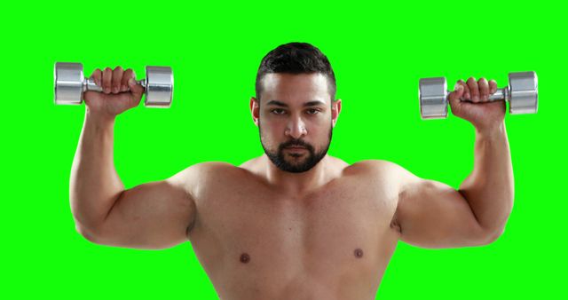 Muscular man engaging in strength training with dumbbells against a green screen background, providing a versatile backdrop for modifications. Ideal for illustrating articles on fitness, strength training programs, healthy lifestyle habits, or marketing for gym equipment. The image can be used for posters, fitness blogs, or instructional workout videos.