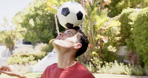 Man Balancing Football on Head Outdoors