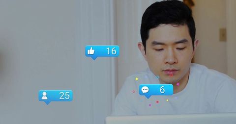 Asian man working remotely on laptop with social media notifications and engagement icons