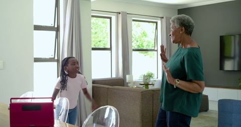 African american grandmother and granddaughter sharing joyful moment with red lunchbox