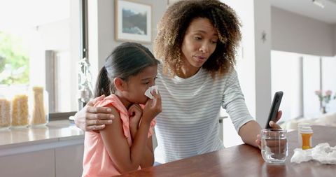 Concerned mother using telemedicine for sick daughter care