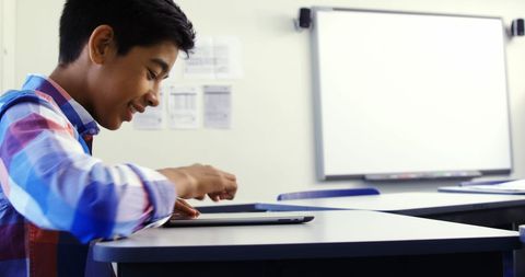 Schoolboy engaging with digital tablet in classroom
