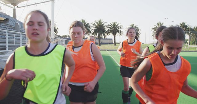 Caucasian female hockey team running on sunny court - Download Free Stock Photos Pikwizard.com