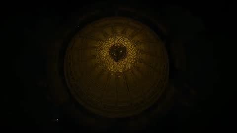 Drone circling, revealing gilded domed ceiling with central chandelier and radial ornament