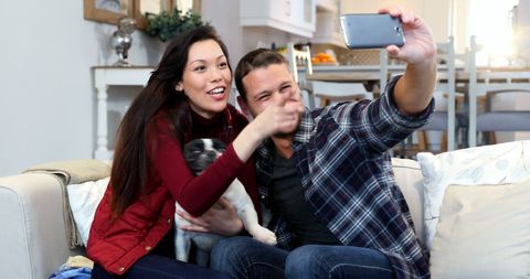 Happy Couple Taking Selfie with Pet at Home