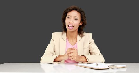 Professional Businesswoman Engaging with Audience on Grey Background