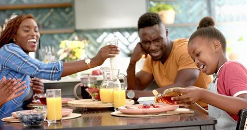Happy african american family sharing lunch and laughter