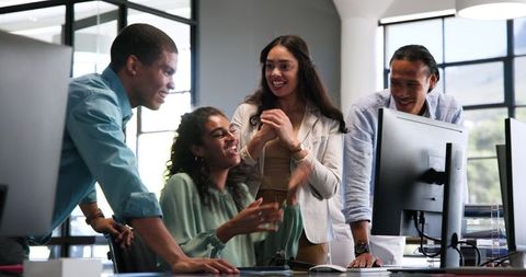 Diverse Team Celebrating Work Achievement in Modern Office