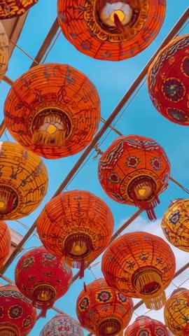 Vertical video tilting up through swaying colorful lanterns, tassels and floral patterns