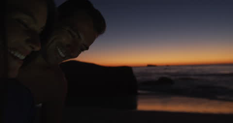 Happy Couple Enjoying Sunset by the Sea with Tablet