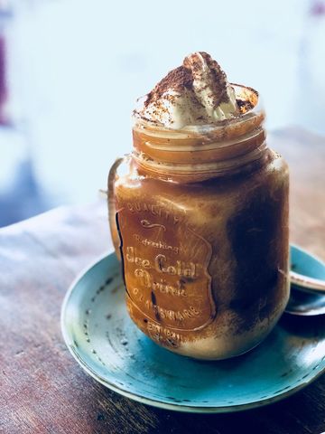 Iced coffee jar with cream and cinnamon