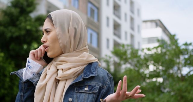 Muslim Woman Talking on Phone Outdoors in Urban Area - Download Free Stock Images Pikwizard.com