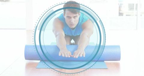Athletic man stretching with foam roller on yoga mat with circular overlay