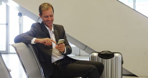 Businessman Engaged with Smartphone in Airport Lounge