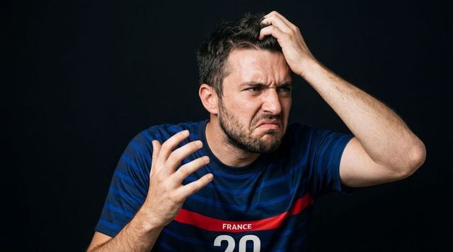 Frustrated male fan clutching hair and gesturing while wearing france jersey number 20