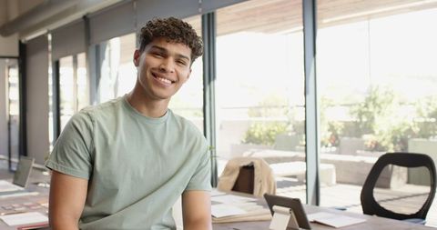 Smiling Man in Modern Office Using Tablet for Productivity