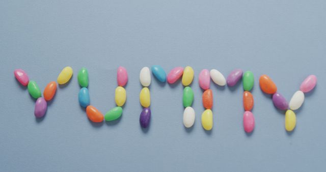 Colorful Jellybeans Arranged to Spell Yummy on Blue Background - Download Free Stock Images Pikwizard.com