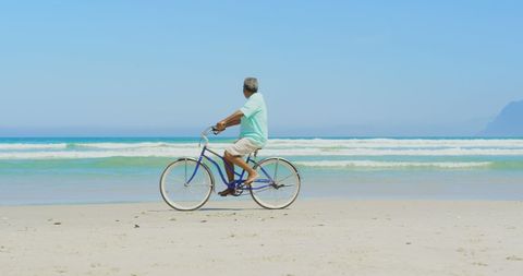 Senior Man Biking on Sunny Beach - Download Free Stock Images Pikwizard.com