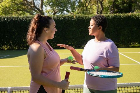 Diverse Friends Conversing on Tennis Court