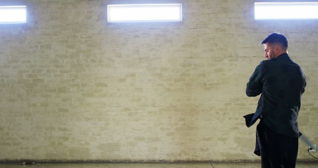 Man Leaning Against Brick Wall in Minimalist Setting - Download Free Stock Images Pikwizard.com