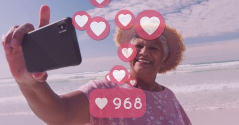 Senior Woman Taking Beach Selfie with Social Media Interaction