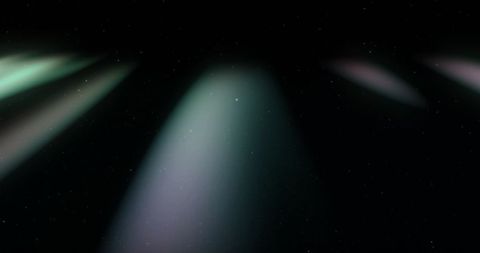Multiple spotlights on black background creating abstract lens flares