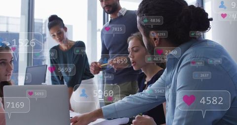 Multicultural team collaborating around laptop with floating digital analytics and engagement icons