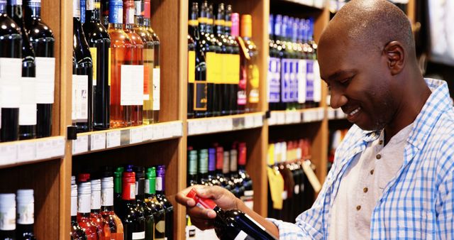 Smiling Man Choosing Wine in Liquor Store - Download Free Stock Images Pikwizard.com