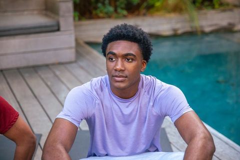 Relaxed man sitting by pool in casual sportswear