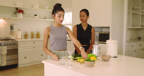 Young Female Friends Preparing Healthy Smoothies in Modern Kitchen